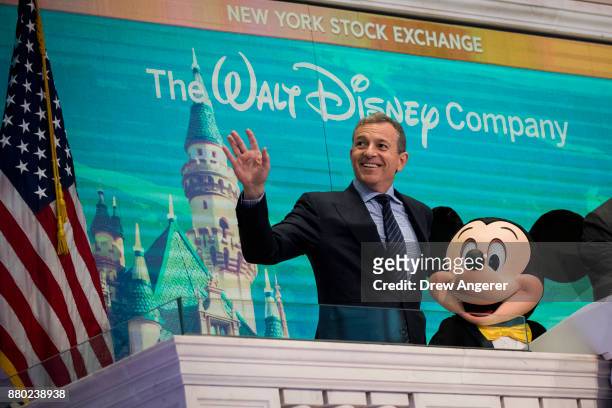 Chief executive officer and chairman of The Walt Disney Company Bob Iger and Mickey Mouse look on before ringing the opening bell at the New York...