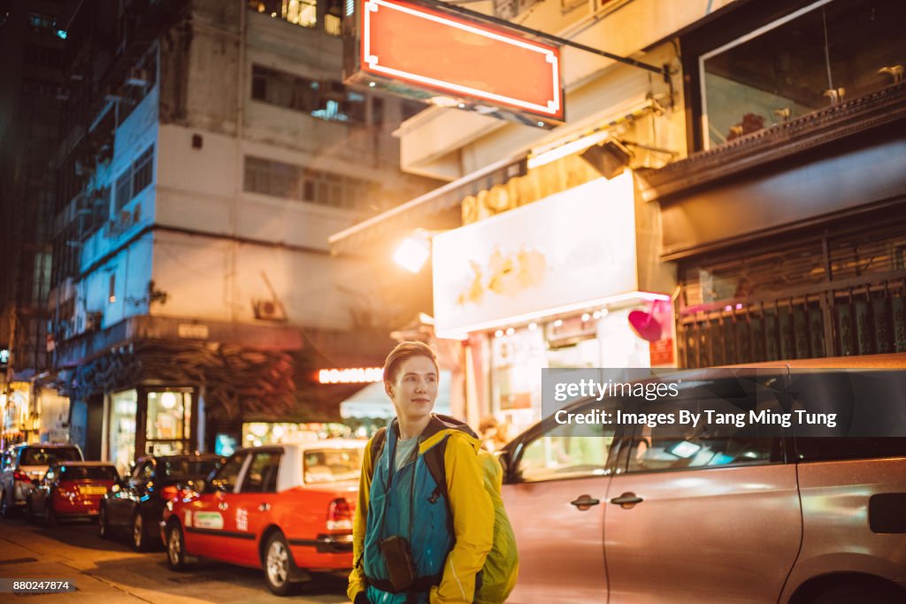 Young caucasian tourist in Hong Kong's street at night time.