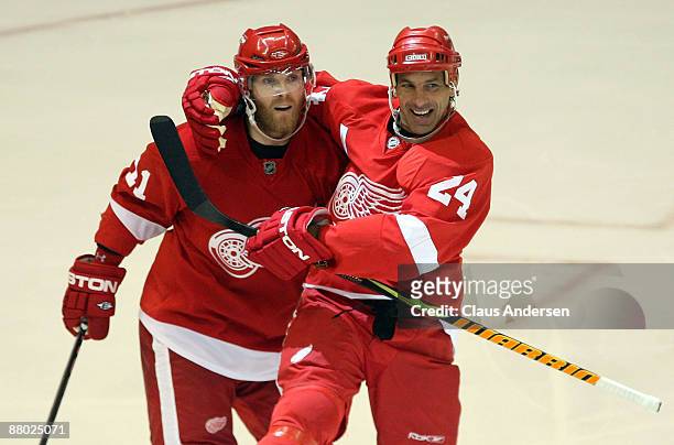 Dan Cleary and Chris Chelios of the Detroit Red Wings celebrate after Cleary scored a goal in the third period against the Chicago Blackhawks during...