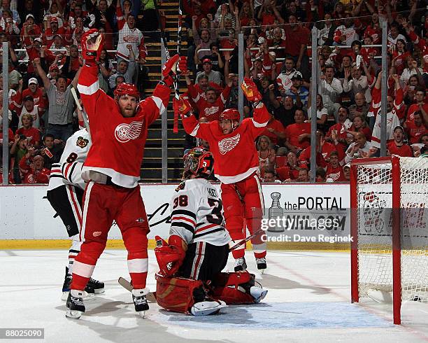 Dan Cleary and Marian Hossa of the Detroit Red Wings celebrate after Cleary's goal as goalie Cristobal Huet of the Chicago Blackhawks looks on during...