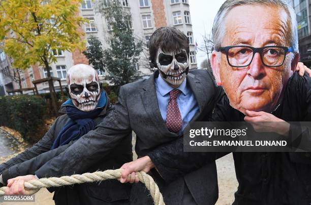 Activists acting as European Commission President Jean-Claude Juncker and Monsanto-characters with their faces painted with a skull enact a...