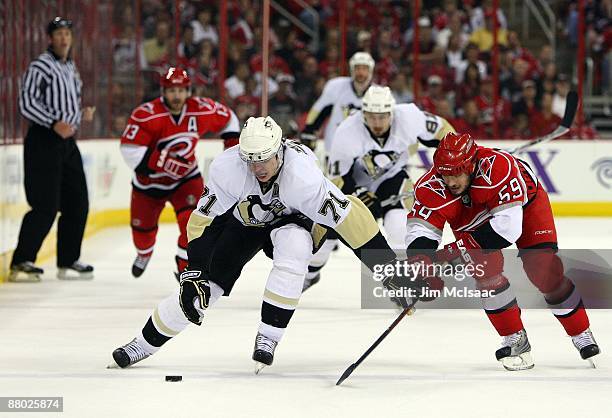 Chad LaRose of the Carolina Hurricanes battles for the puck against Evgeni Malkin of the Pittsburgh Penguins during Game Four of the Eastern...