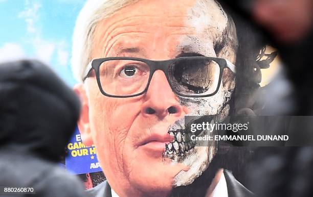 Pedestrian looks at a truck displaying a billboard featuring European Commission President Jean-Claude Juncker during an action calling for the EU...