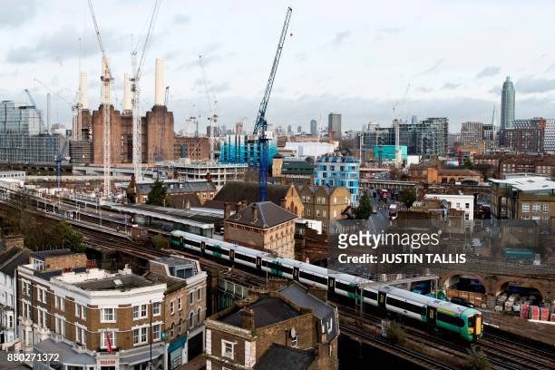 Southern Trains passenger trains pass through Battersea Park rail station as construction work continues on the Battersea Power Station residential...
