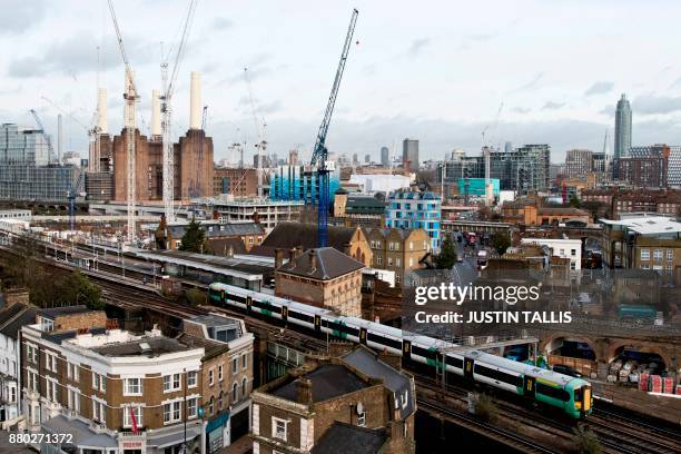 Southern Trains passenger trains pass through Battersea Park rail station as construction work continues on the Battersea Power Station residential...