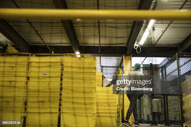 An employee moves plastic bins at the Amazon.com Inc. Fulfillment center in Robbinsville, New Jersey, U.S., on Monday, Nov. 27, 2017. The holiday...