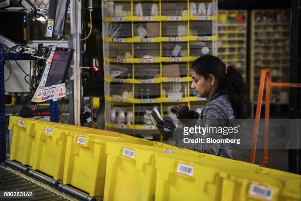 An employee scans an item while filling an online order at the Amazon.com Inc. Fulfillment center in Robbinsville, New Jersey, U.S., on Monday, Nov....