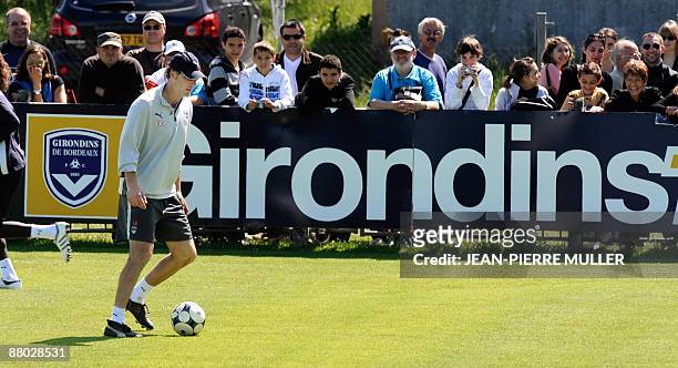 Bordeaux' coach Laurent Blanc walks with a ball eyed by supporters, on May 28 at the training center of French football club Girondins de Bordeaux,...