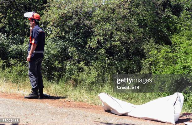 Bulgarian rescue worker stands near a cadavre following a bus crash near the eastern Bulgarian town of Yambol on May 28, 2009. At Sixteen people died...