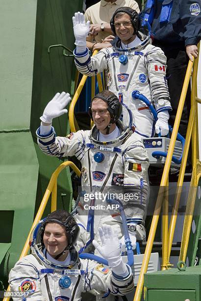 Canadian astronaut Robert Thirsk , European Space Agency astronaut Frank De Winne of Belgium and Russian cosmonaut Roman Romanenko wave before...