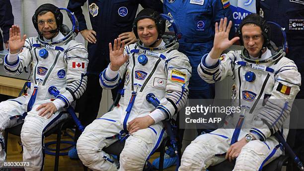 Canadian astronaut Robert Thirsk , European Space Agency astronaut Frank De Winne of Belgium , and Russian cosmonaut Roman Romanenko wave after...