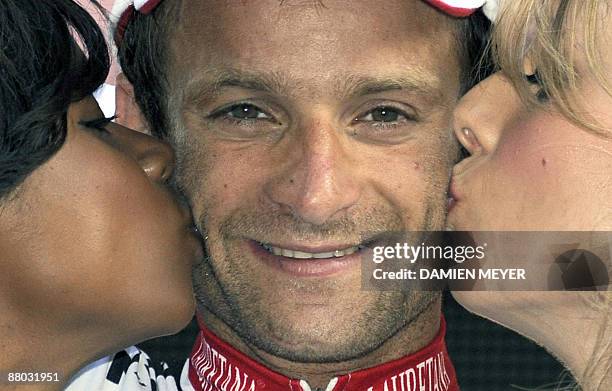 Italy's Michele Scarponi gets the kiss of two beauties on the winner stand after he carried off the eightteenth stage of 92nd Giro of Italy between...