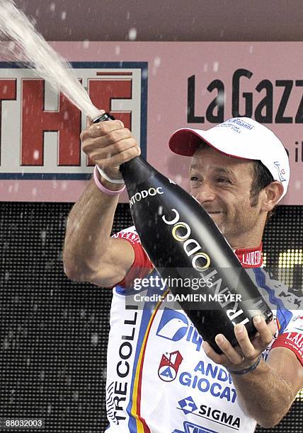 Italy's Michele Scarponi sprays champagne on the winner stand after he carried off the eightteenth stage of 92nd Giro of Italy between Sulmona and...