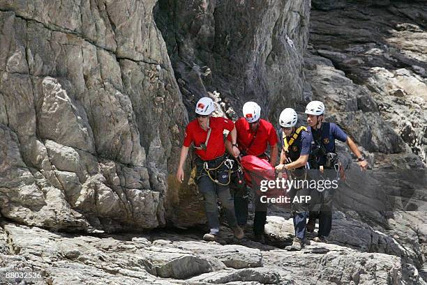 Rescuers carry the body of a six-year-old German girl less than 24 hours after she was reported missing, at the foot of a cliff, near Ermita de Sant...