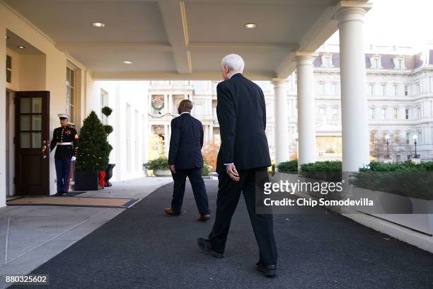 Senate Finance Committee Chairman Orrin Hatch and Sen. Tim Scott walk back into the West Wing after talking with reporters following a lunch meeting...