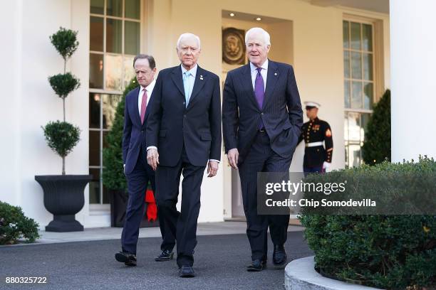 Senate Finance Committee members Sen. Pat Toomey and Sen. John Cornyn walk out of the West Wing with Chairman Orrin Hatch following a lunch meeting...