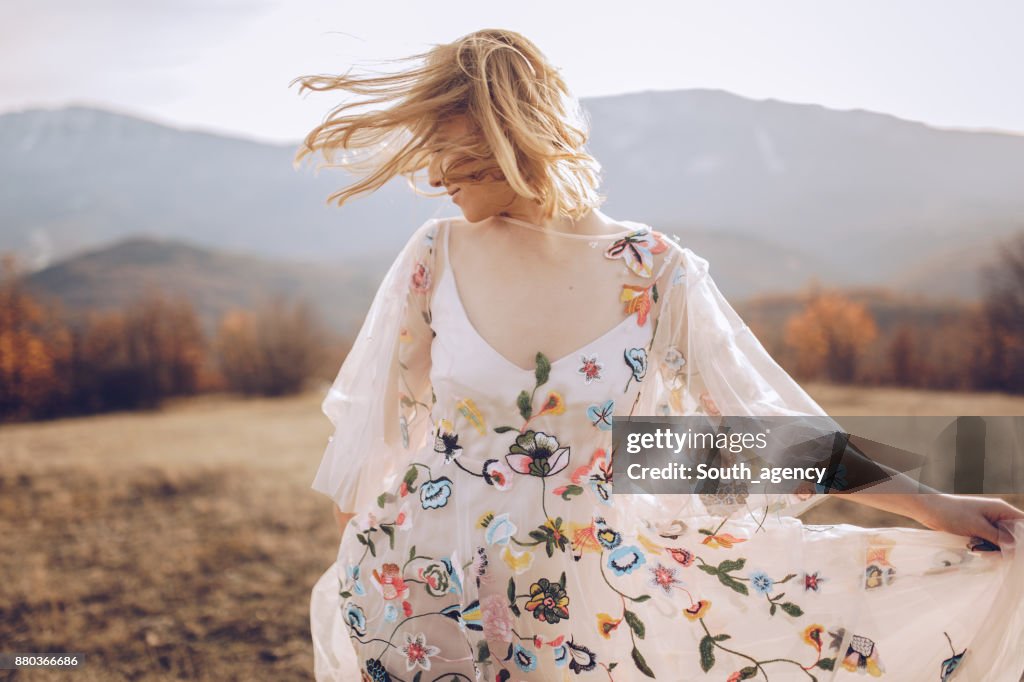 Beautiful hippie woman dancing in a meadow