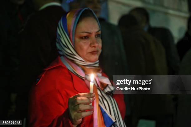 People take part during a candlelight vigil as they hold national flags for victims of a Friday mosque attack at the Journalists Syndicate, in Cairo,...