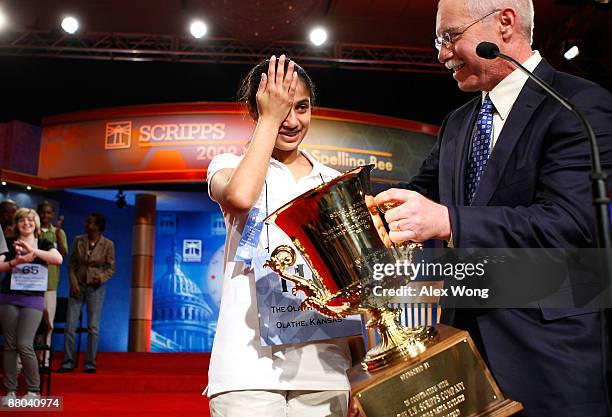 Speller Kavya Shivashankar of Olathe, Kansas, wipes her tears as she receives the trophy from President and CEO of The E.W. Scripps Company Richard...