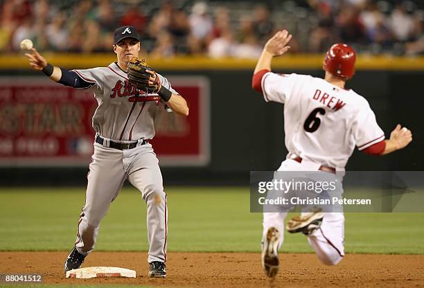 Infielder Kelly Johnson of the Atlanta Braves throws over the sliding Stephen Drew of the Arizona Diamondbacks to complete a double play during the...