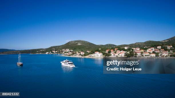 aerial of cruise ship ms romantic star (reisebüro mittelthurgau) and sailboat with houses along coastline behind, slano, dubrovnik-neretva, croatia - reisebüro stockfoto's en -beelden