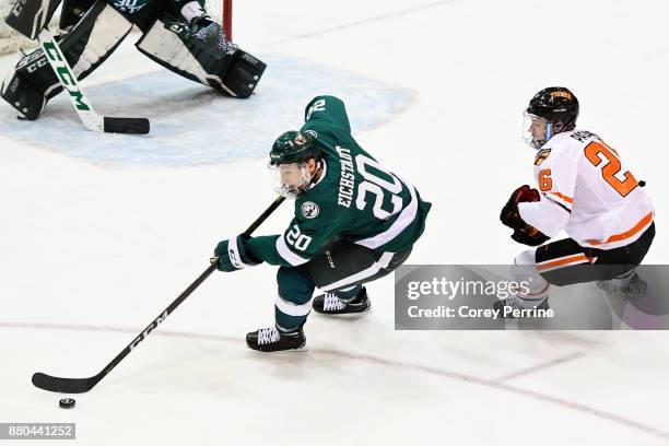 Dillon Eichstadt of the Bemidji State Beavers handles the puck against Jake Paganelli of the Princeton Tigers during the first period at Hobey Baker...