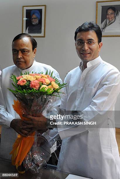 Indian Junior Minister for Petroleum and Natural Gas Jitin Prasad presents a bouquet to Union Minister for Petroleum Murali Deora as they took charge...