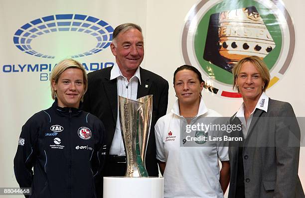 Team captain Jennifer Zietz and headcoach Bernd Schroeder of Potsdam and team captain Inka Grings and headcoach Martina Voss of Duisburg pose with...