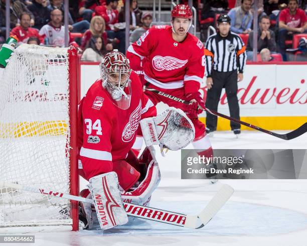 Petr Mrazek and Xavier Ouellet of the Detroit Red Wings follows the play against the Edmonton Oilers during an NHL game at Little Caesars Arena on...
