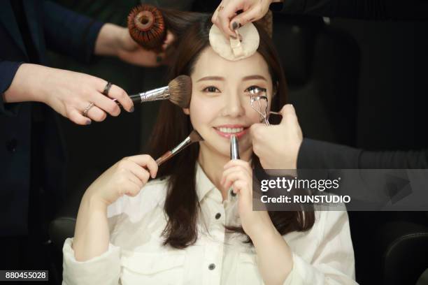 woman having makeup applied by stylists - makeup artist stock pictures, royalty-free photos & images