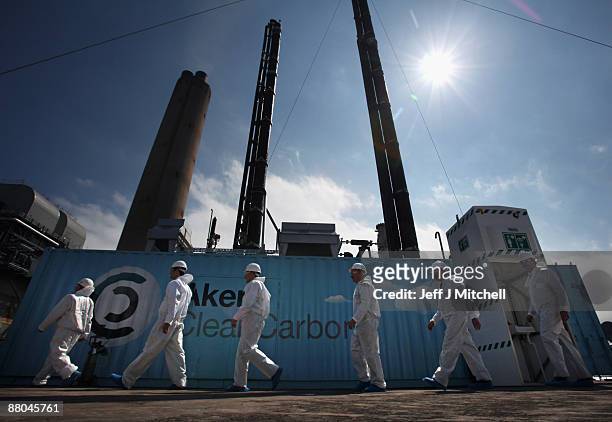 Scientist stand beside a new carbon capture test unit at Longanet power station on May 29, 2009 in Longanet, Scotland. The new technology being...
