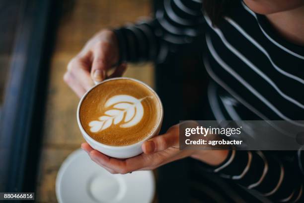 manos de la señora sosteniendo la taza con algo en forma de corazón - chica-tomando-cafe fotografías e imágenes de stock