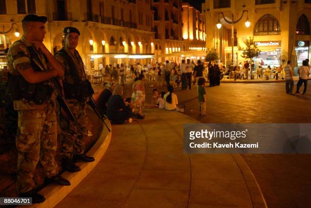 Lebanese soldiers stand guard while people enjoy a summer evening in the Place de l'Etoile in downtown Beirut, Lebanon, 6th August 2008.