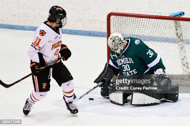 Alex Riche of the Princeton Tigers can't convert a pass into a goal as Jack Burgart of the Bemidji State Beavers deflects the puck during the second...