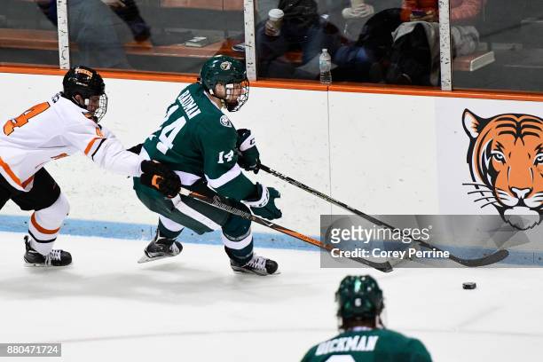 Josh Teves of the Princeton Tigers pressures Kyle Bauman of the Bemidji State Beavers during the second period at Hobey Baker Rink on November 24,...