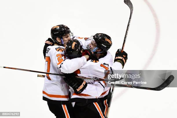 Joe Grabowski, Tigers David Hallisey and Mark Paolini of the Princeton Tigers hug after a goal against the Bemidji State Beavers during the third...