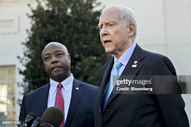 Senator Orrin Hatch, a Republican from Utah and chairman of the Senate Finance Committee, speaks to members of the media as Senator Tim Scott, a...