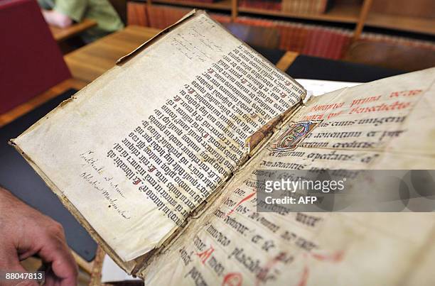 Person shows on May 29, 2009 in Colmar, northeastern France shows an extract from the Gutenberg Bible discovered in a library by a library assistant,...