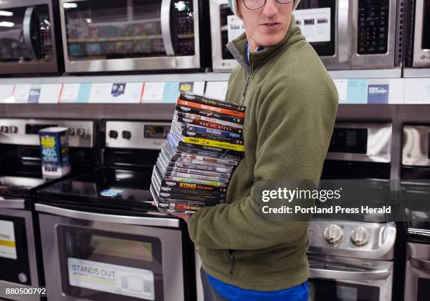 Trystan Mericer stands with his stack of DVDs in the long line to check out at Best Buy in the Maine Mall just after midnight on Black Friday....