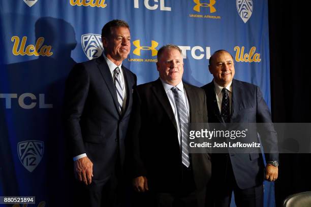 Troy Aikman, Chip Kelly and UCLA Director of Athletics Dan Guerrero stand on stage for a photograph after a press conference introducing Kelly as the...