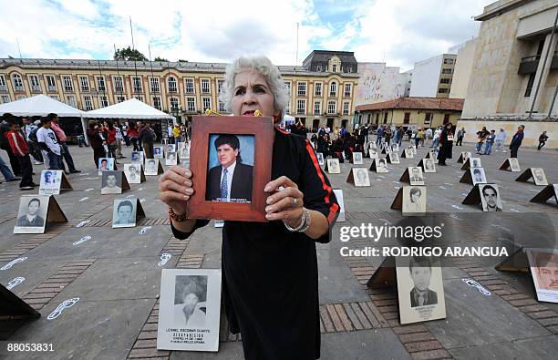 Woman shows the picture of a man who allegedly went missing by actions of the Colombian security forces, at Bolivar Square in Bogota on May 29, 2009....