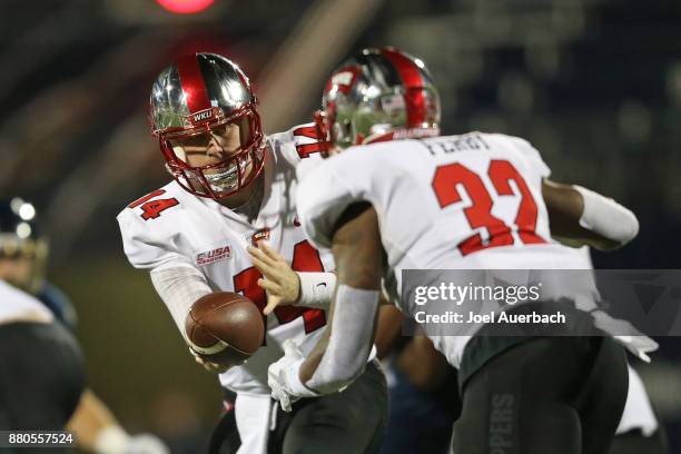 Mike White hands the ball off to D'Andre Ferby of the Western Kentucky Hilltoppers against the Florida International Golden Panthers on November 24,...