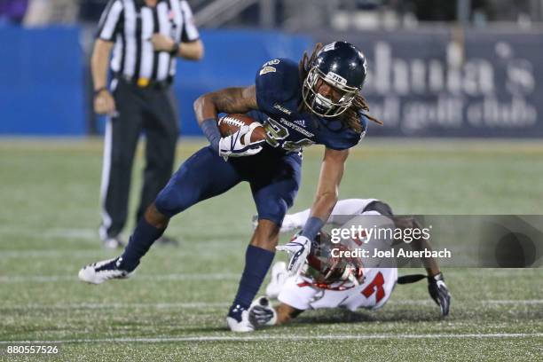 Vonte Price of the Florida International Golden Panthers eludes the tackle of Joe Brown of the Western Kentucky Hilltoppers on November 24, 2017 at...