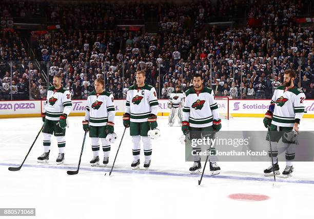 Daniel Winnik, Mikael Granlund, Mikko Koivu, Matt Dumba and Kyle Quincey of the Minnesota Wild stand on the ice during the singing of the National...