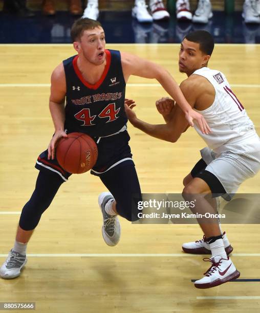 Bryce Aiken of the Harvard Crimson guards Cullen Neal of the St. Mary's Gaels as he takes the ball down court during the game at the Titan Gym on...