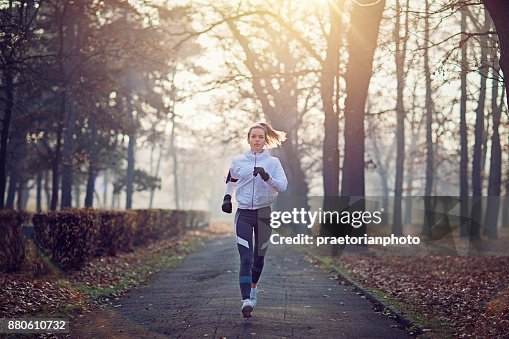 Young woman is running in the cold foggy morning Young woman is running in the cold foggy morning
