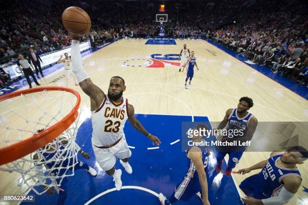 LeBron James of the Cleveland Cavaliers dunks the ball past Robert Covington, Dario Saric, Joel Embiid, and Ben Simmons of the Philadelphia 76ers in...