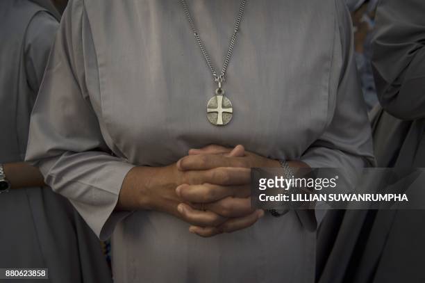 Catholic nun from Myanmar clasps her hands in prayer at St. Francis of Assisi Catholic Church in Yangon on November 28 a day after the arrival of...