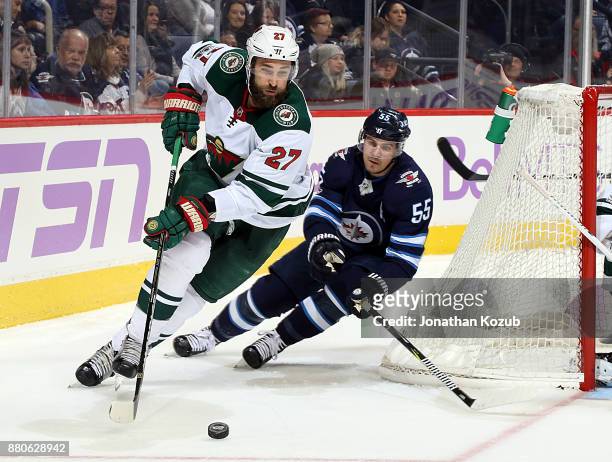 Kyle Quincey of the Minnesota Wild plays the puck around the net away from Mark Scheifele of the Winnipeg Jets during second period action at the...