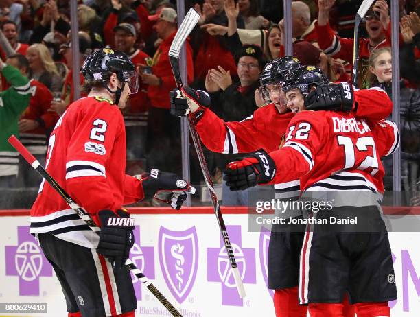 Duncan Keith, Patrick Kane and Alex DeBrincat of the Chicago Blackhawks celebrate DeBrincats' third goal of the game in the second period against the...